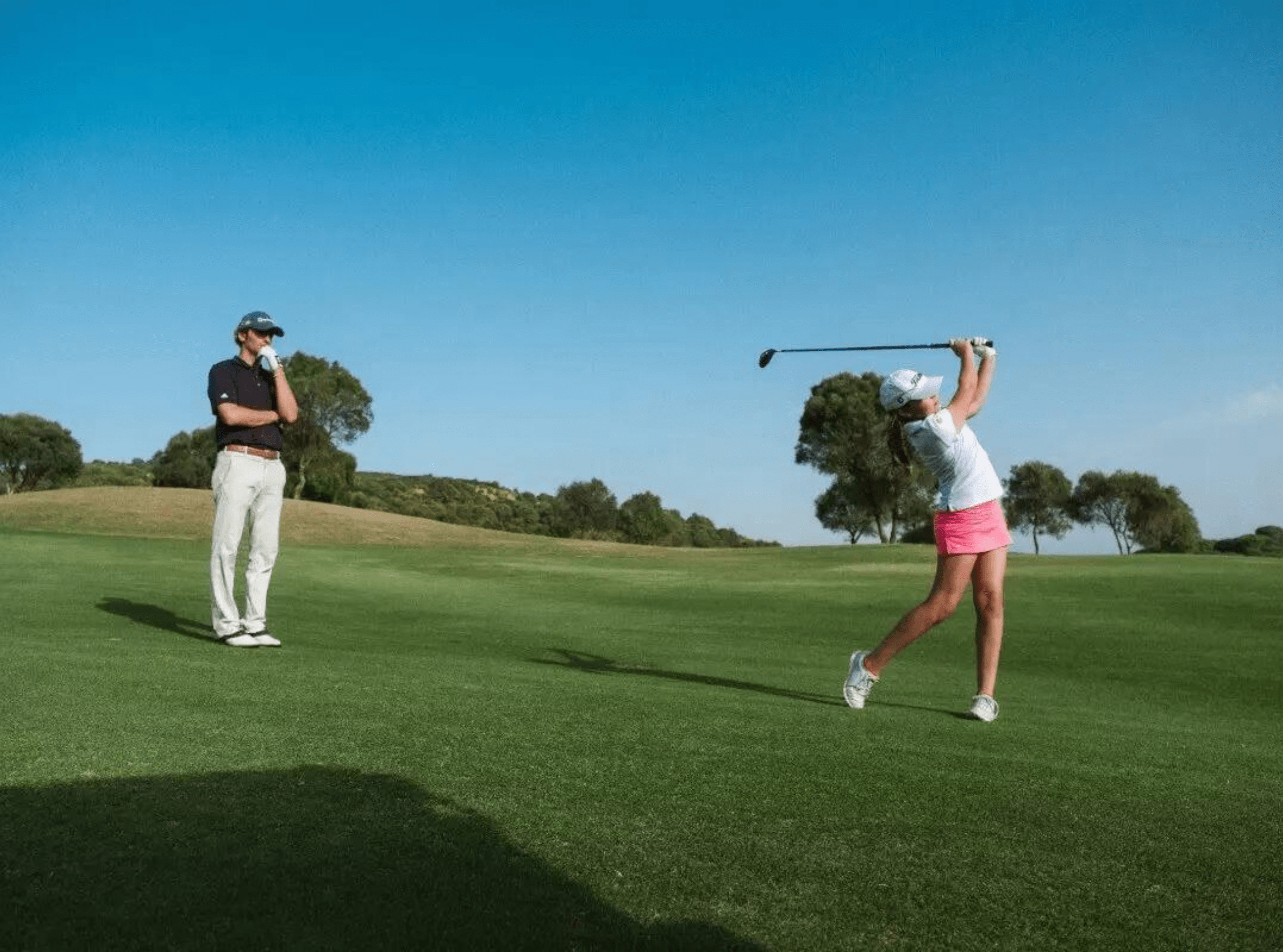 Two individuals playing golf on the prestigious grounds of Sotogrande, enjoying the luxury amenities and leisure activities offered by the esteemed real estate community.