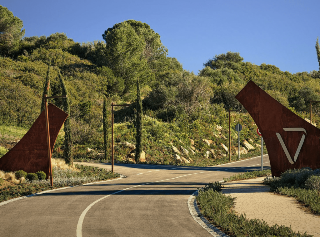 A road leading to a private area amidst a picturesque mountainous region with abundant trees, showcasing the exclusive real estate offerings of Sotogrande. The tranquil natural surroundings complement the luxurious properties, highlighting the allure of Sotogrande's real estate market.