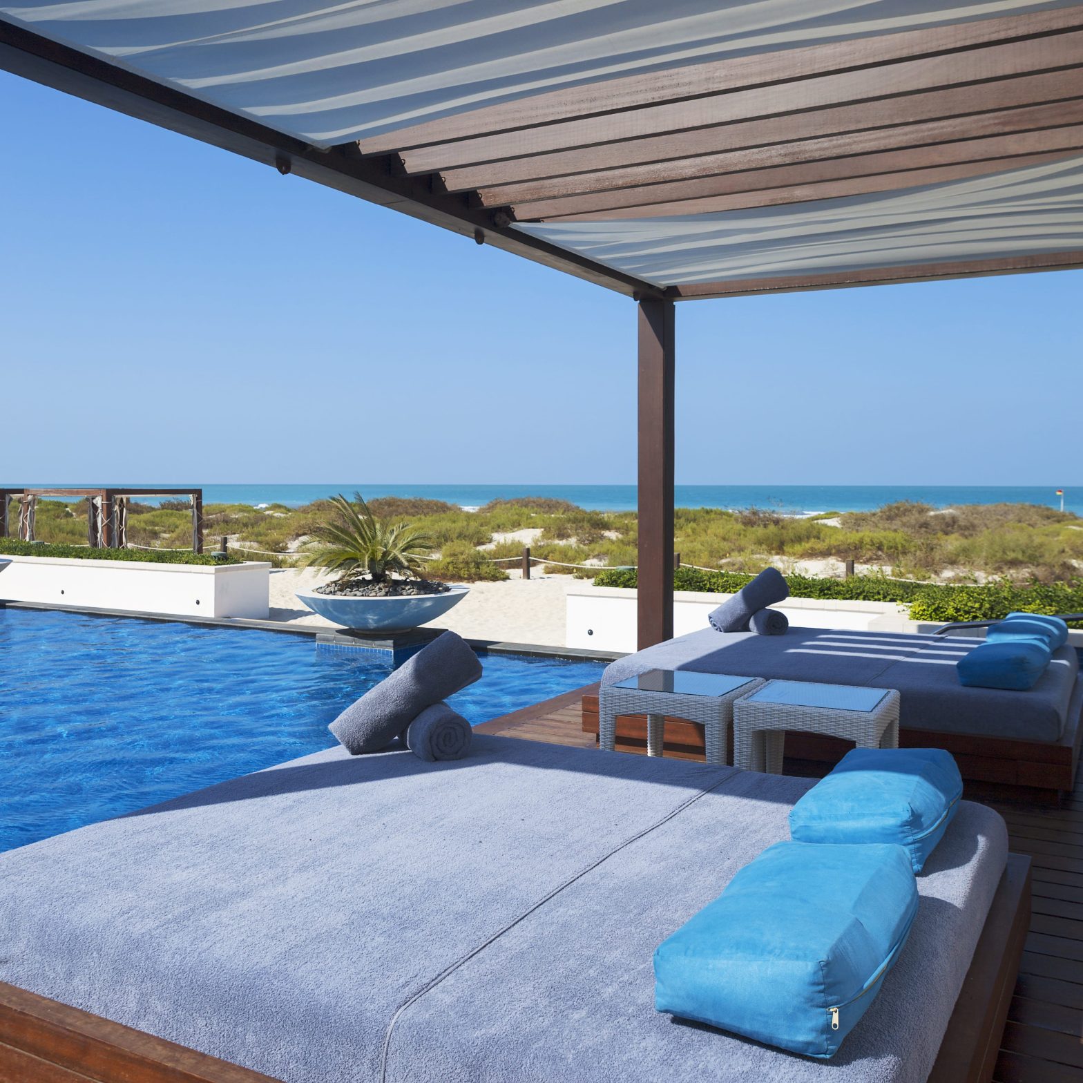 Luxurious beachfront villa with a pool and sunbeds in Sotogrande, Spain.