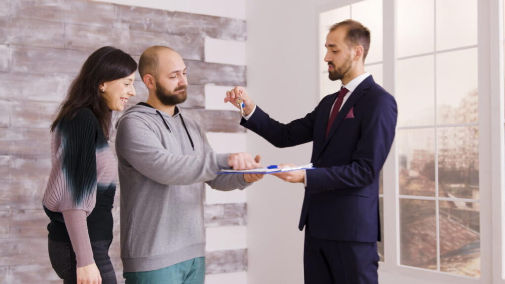 Real estate agent handing over keys to buyers during a property viewing, representing a Sotogrande house for sale.